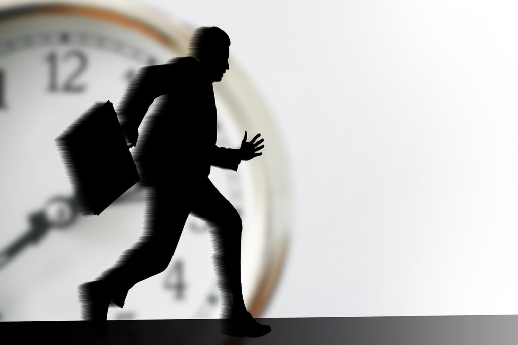 Un employé stressé et pressé par le travail court avec son cartable à la main.
